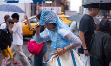 A woman crosses the street during a rain storm in New York City