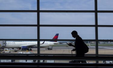 A passenger walks through the terminal at Ronald Reagan Washington National Airport. Strong demand for travel should keep airfares high the rest of this year