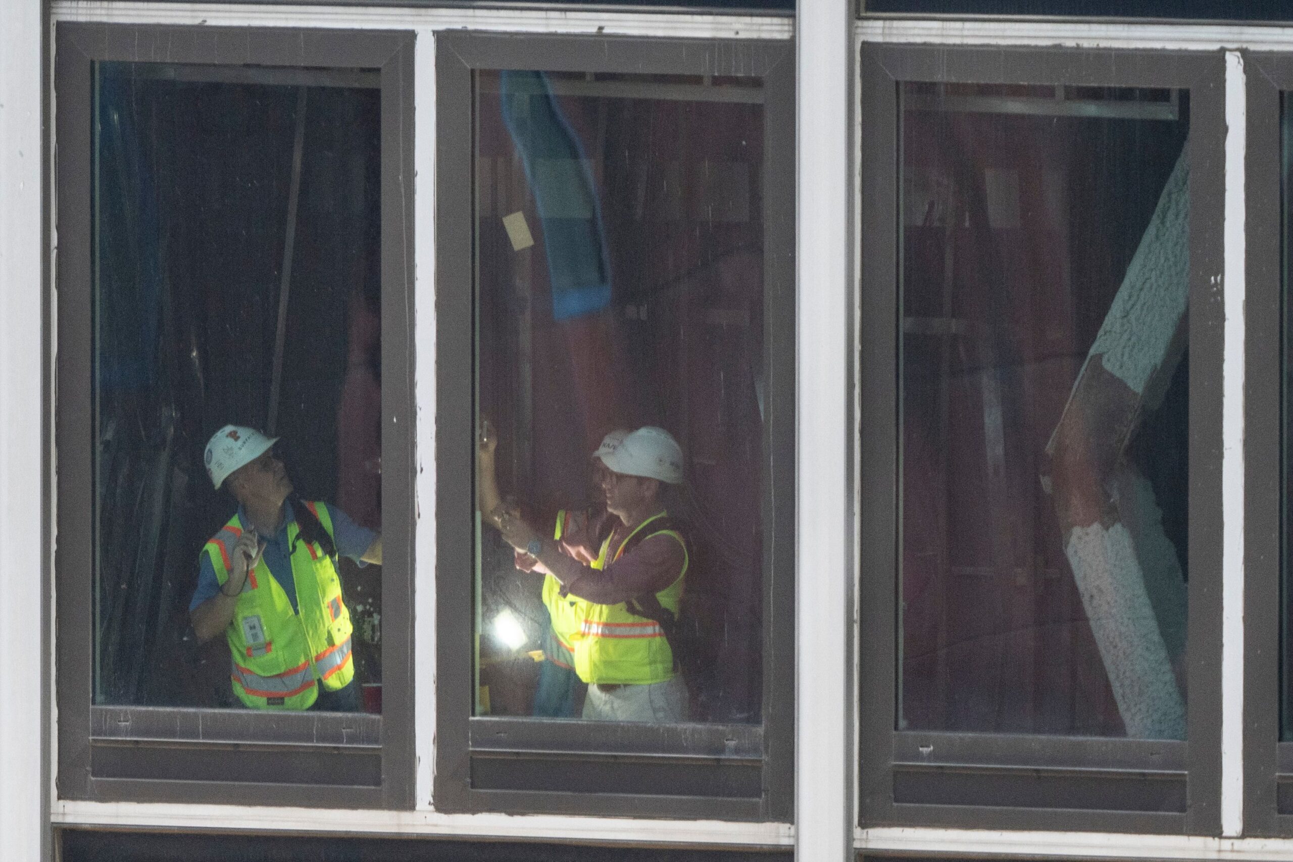 <i>Yuki Iwamura/AP via CNN Newsource</i><br/>People inspect a buckled support beam inside 235 East 42nd Street
