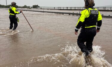Game wardens walk through high waters from heavy rains in Uvalde County