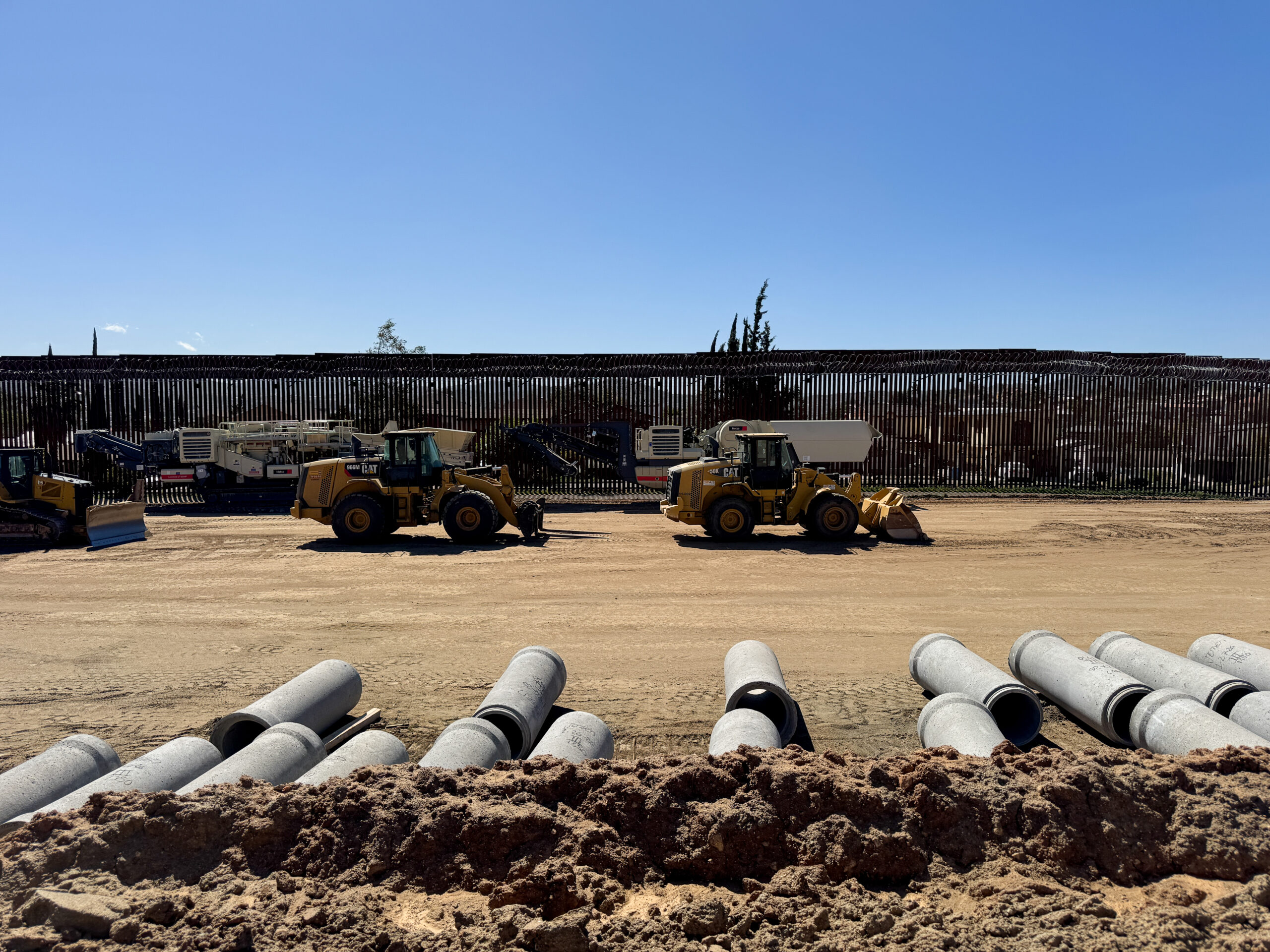 Border wall and construction equipment.
