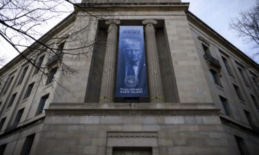 A a new banner featuring an image of US President Donald Trump is displayed on the facade of the US Department of Justice headquarters