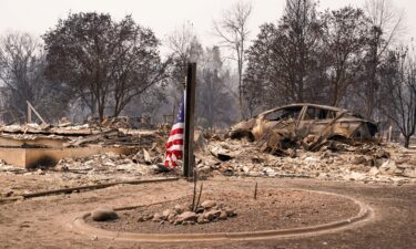 An American flag is seen in a neighborhood damaged by the Old Trails Fire in Spokane