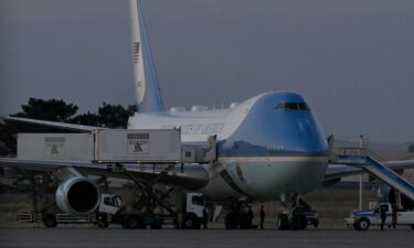 US President Donald Trump walks down the stairs during a stop to switch to the Qatari-gifted Air Force One after arriving on one of the older planes operating as Air Force One