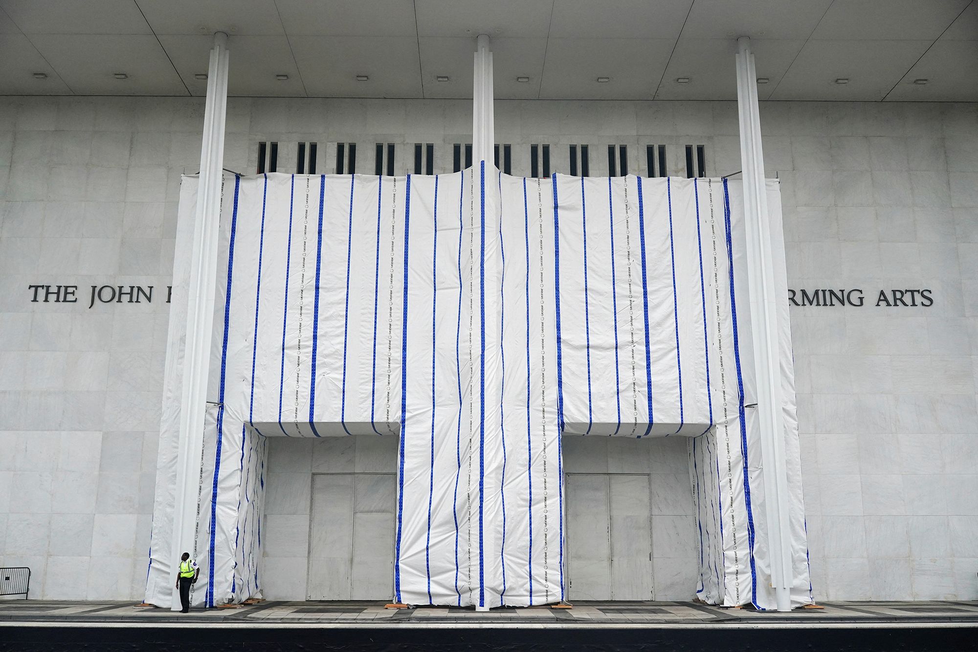 <i>Nathan Howard/Reuters via CNN Newsource</i><br/>A tarp covers the facade of the John F. Kennedy Memorial Center following a federal judge’s order to remove US President Donald Trump's name from the institution in Washington