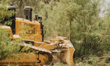 Construction workers walk near a bulldozer near the border in Big Bend National Park in Texas on August 7