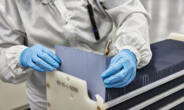 An employee inspects a silicon wafer at the Hanwha QCells solar panel manufacturing plant.
