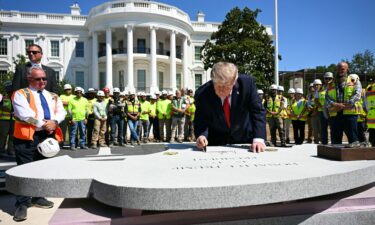US President Donald Trump signs a piece of stone at the construction site of a helipad on the South Lawn of the White House in Washington