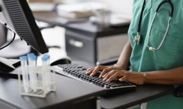 A nurse works at a computer.
