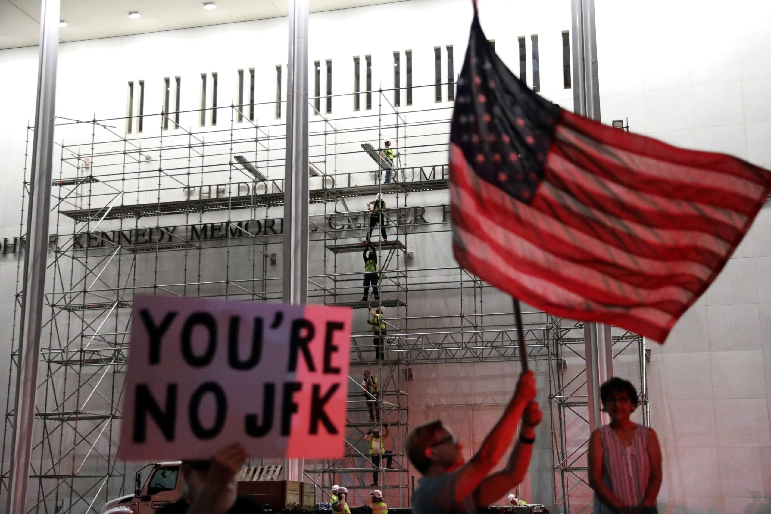 <i>Rahmat Gul/AP via CNN Newsource</i><br/>People wait for President Donald Trump's name to be removed from the John F. Kennedy Center for the Performing Arts in Washington