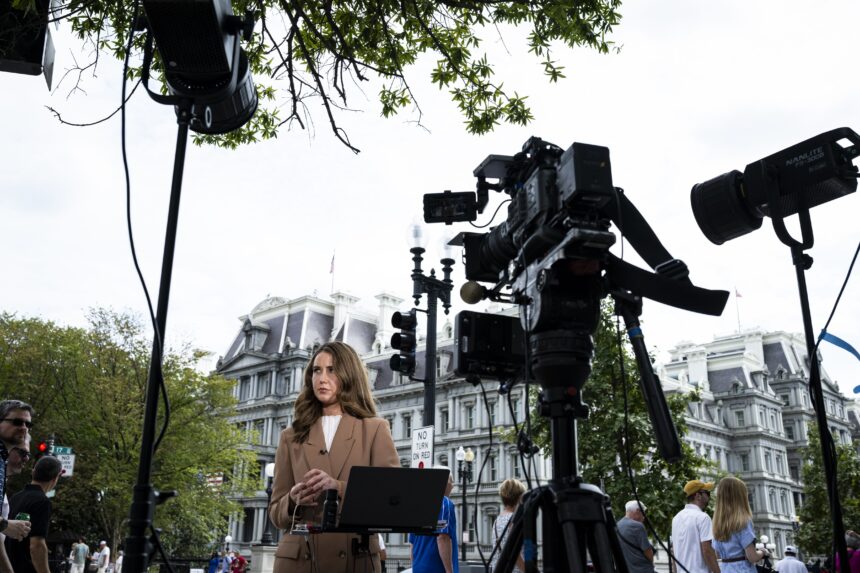 CNN Correspondent Julia Benbrook prepares for a television report on a street corner outside the White House grounds after earlier being denied entry