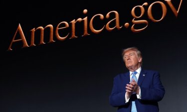 President Donald Trump applauds on stage during the America.gov launch event at Andrew W. Mellon Auditorium in Washington