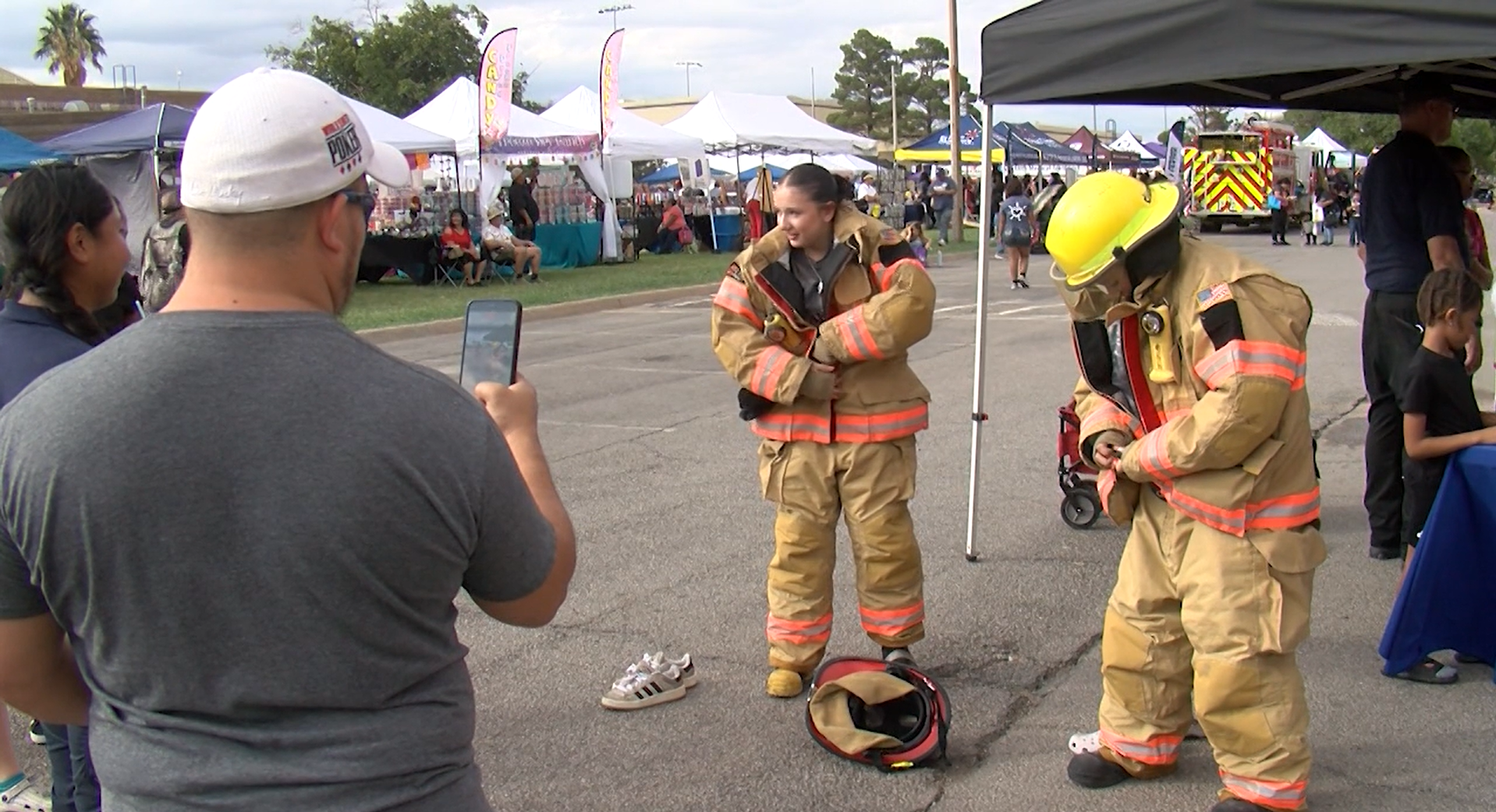 Two attendees attempt to put on firefighter gear.
