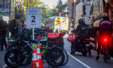 Delivery workers pick up orders outside a grocery store in New York on Tuesday.