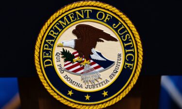 The US Department of Justice logo is seen on a podium before a news conference