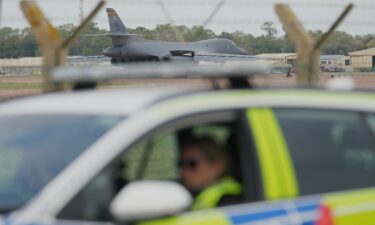 A B1 bomber prepares to take off as police officers guard a checkpoint near RAF Fairford in Fairford
