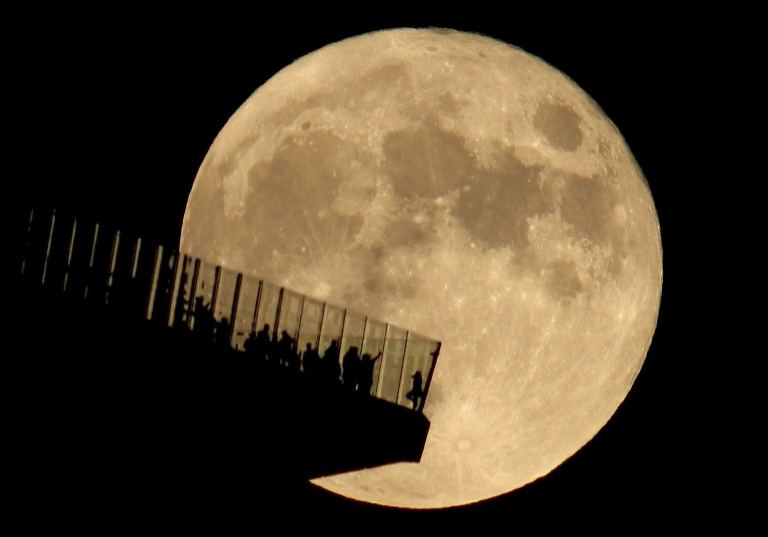 <i>Gary Hershorn/Corbis News/Getty Images via CNN Newsource</i><br/>People standing on the Edge NYC watch a full hunter's moon rising in New York in October 2021.