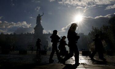 A police officer ties in place a perimeter tape near Chatelet - Les Halles to enforce a curfew