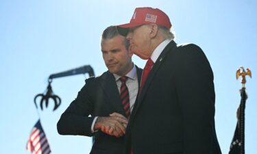 US President Donald Trump shakes hands with Secretary of Defense Pete Hegseth in Sparrows Point