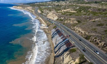 Protective plastic sheeting covers a long crack in a hillside alongside the southbound lanes of the Pacific Coast Highway at Moro Beach on Thursday